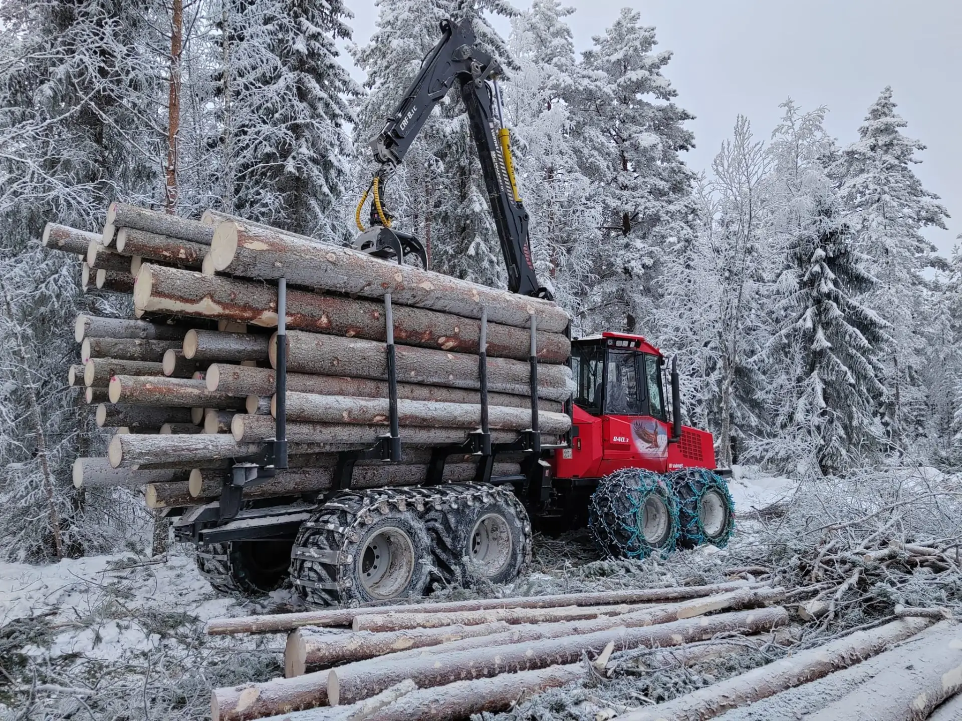 Maakvist metsäkone tukkikuormalla talvella